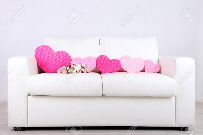 26362627-pink-hearts-shaped-pillow-and-flowers-on-white-sofa.jpg